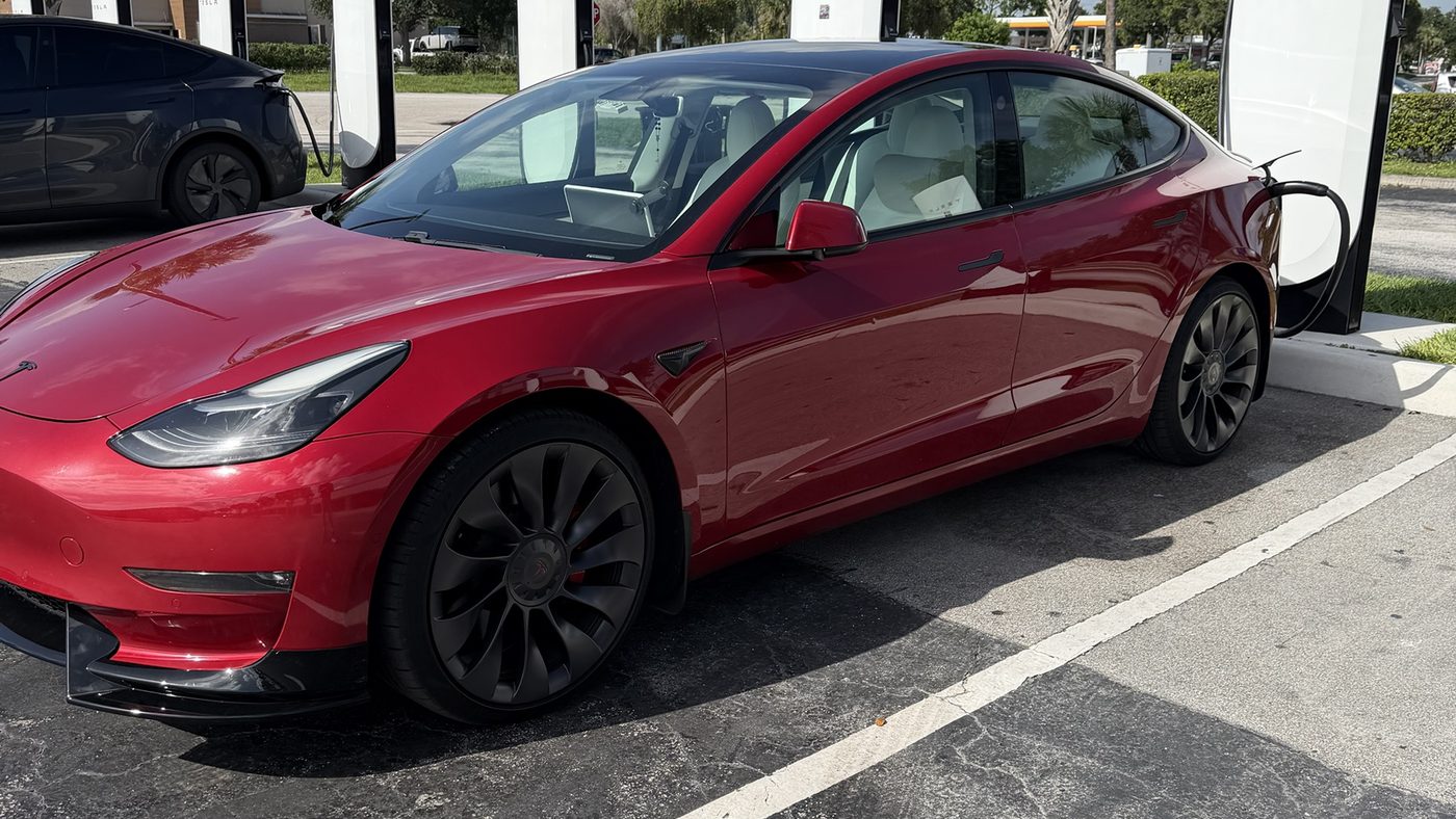 Red 2021 Tesla Model 3 Performance at a Tesla Supercharger